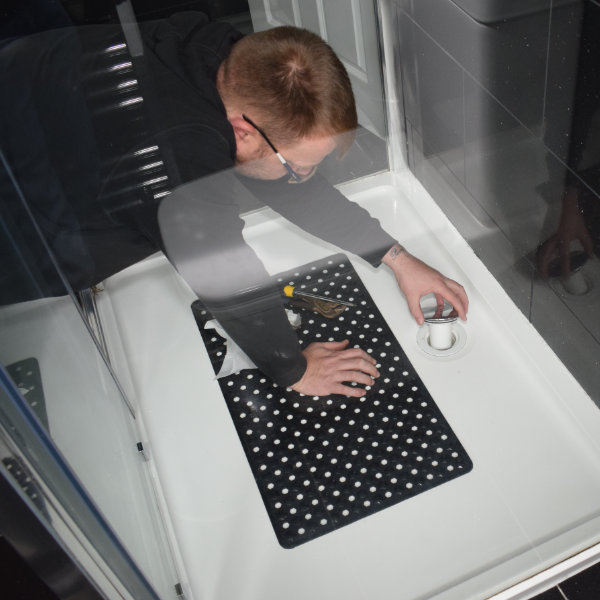 A Buxton plumber fitting the shower plug to a newly installed bathroom in SK17
