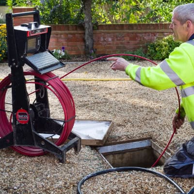 A drain specialist doing a drain unblock at a house