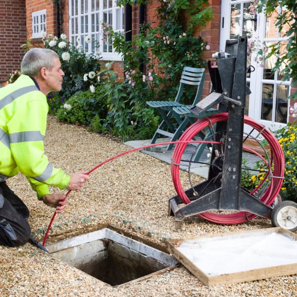 A drain being unblocked by a drainage engineer