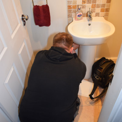A Buxton emergency plumber repairing a leak in a downstairs toilet in a house in SK17