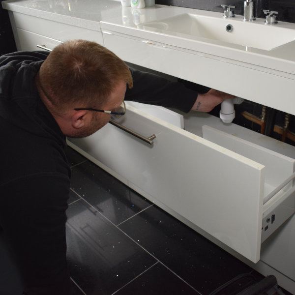 A plumber in Buxton coming out to fix an emergency sink leak in a bathroom in SK17
