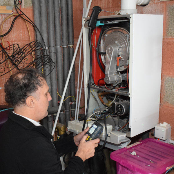A corgi registered plumber in Buxton servicing a gas boiler