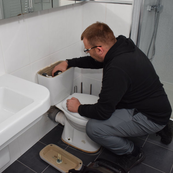 A Buxton plumber fixing a broken toilet in a house in SK17