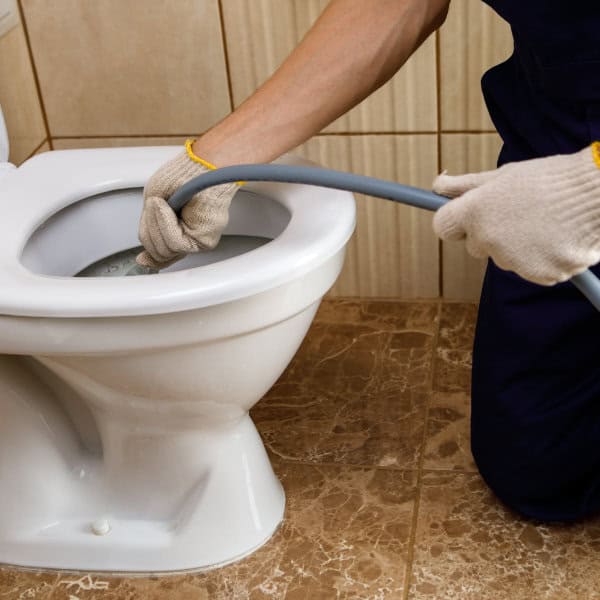 A drainage expert unblocking a blocked toilet